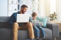 What you working on son. a cheerful little boy and his father using a laptop and a digital tablet while being seated on Royalty Free Stock Photo