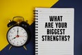 What Are Your Biggest Strengths? text written on notepad with alarm clock on yellow background Royalty Free Stock Photo