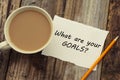 What Are Your Goals question as memo on white blank paper with cup of coffee. Rustci wooden background. Royalty Free Stock Photo