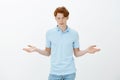 What is your point, cannot understand. Portrait of unaware confused young handsome guy in trendy clothes, raising hands
