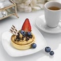 Whate tea and cake with strawberry and blueberries on white plates on a white table Royalty Free Stock Photo