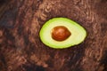 Whatever the question, avo is the answer. High angle shot of an avocado cut in half on a wooden table.