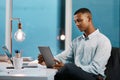 Whats trending today in the business world. a handsome young businessman using a digital tablet while working late in