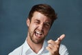 Whats up. Studio portrait of a handsome young man making a face against a dark background. Royalty Free Stock Photo