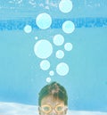 Whats on your mind. Shot of a little boy swimming underwater with bubbles above his head. Royalty Free Stock Photo