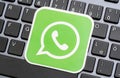 WhatsApp online communicator, messaging app green logo symbol, closeup detail, card laying on a modern computer keyboard, nobody Royalty Free Stock Photo