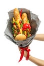 Wheat bread, sesame bun, cheese of different varieties, sausages and pepper are wrapped in gray paper as a gift bouquet in male ha Royalty Free Stock Photo