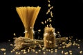 Wheat bunch, macaroni and pasta in jar, on black background. Grain bouquet, golden spikelets on dark wooden table.
