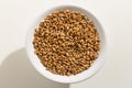 Wheat cereal grain. Top view of grains in a bowl. White background.