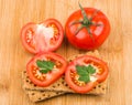 Wheat crisp bread and tomato on bamboo board Royalty Free Stock Photo