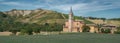 Wheat field, church and old ruined house hill ridge with badlands and vineyards in the background.