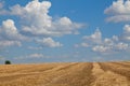 Wheat field after harvesting, golden stubble under blue sky, ukrainian flag. Ukraine Royalty Free Stock Photo