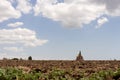 Wheat field of ripe wheat against the blue sky and beautiful clouds. Arable land, the church in the background Royalty Free Stock Photo