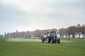 Wheat field tractor spraying agrochemical or agrichemical over y