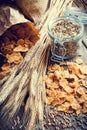 Wheat flakes, spikes and rye grain on wooden table