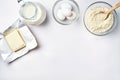 Wheat flour in the glass bowl, cream in a glass jar, butter, chicken eggs - ingredients for the dough, top view