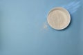 Wheat flour in a white deep plate, a little awake on a blue background. Royalty Free Stock Photo