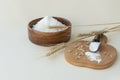 wheat flour in a wooden bowl and in a spoon on a board, near ears of wheat and some grains on a light background. Royalty Free Stock Photo