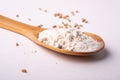 Wheat flour in wooden spoon spatula near with heap of grains, angle view, isolated on white background Royalty Free Stock Photo