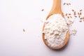 Wheat flour in wooden spoon spatula near with heap of grains, top view, flat lay, isolated on white background Royalty Free Stock Photo