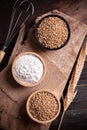 Wheat grain, flour and whisk for bakery cooking on wooden background Royalty Free Stock Photo