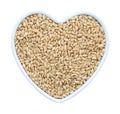 Wheat grain in heart shaped porcelain dish isolated on white background Royalty Free Stock Photo