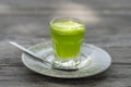 Wheat grass juice natural drink with fresh wheatgrass in glass on old wooden table background. Organic healthy organic green detox