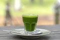 Wheat grass juice natural drink with fresh wheatgrass in glass on old wooden table background. Organic healthy organic green detox