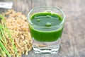 Wheat grass juice on wood background Royalty Free Stock Photo