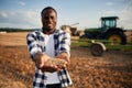 With wheat in hands. Beautiful African American man is in the agricultural field Royalty Free Stock Photo
