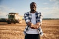 With wheat in hands. Beautiful African American man is in the agricultural field Royalty Free Stock Photo