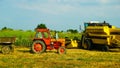 wheat harvesting in a summer day with an old tractor Royalty Free Stock Photo