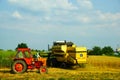 wheat harvesting in a summer day with an old tractor Royalty Free Stock Photo