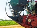 Wheat harvesting in the summer. Red harvester working in the field. Golden ripe wheat harvest agricultural machine harvester on