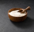 Wheat or oat flour in a wooden bowl with scoop on a dark background. Organic baking ingredients. Concept of homemade and healthy Royalty Free Stock Photo