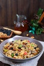 Wheat porridge with nuts, dried berries, raisins, poppies in a ceramic bowl