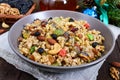 Wheat porridge with nuts, dried berries, raisins, poppies in a ceramic bowl