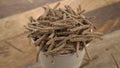 Wheat rye bran flakes fall into a full cup in slow motion.