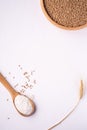 Wheat seeds grains in wooden bowl near with flour in spoon spatula with heap of grains and with ear of wheat, top view Royalty Free Stock Photo