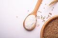 Wheat seeds grains in wooden bowl near with flour in spoon spatula with heap of grains and with ear of wheat, top view Royalty Free Stock Photo