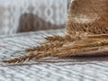 Wheat spikelets and straw hat on white table Royalty Free Stock Photo