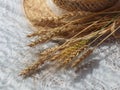 Wheat spikelets and straw hat on white table Royalty Free Stock Photo
