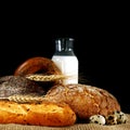 Wheat spikes and bread on the table with a bottle of milk Royalty Free Stock Photo