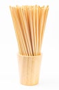 Wheat straw for drinking water in wooden glass on white background