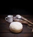 Wheat yeast dough in a wooden bowl on a table Royalty Free Stock Photo