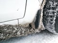 The wheel arch of the car is clogged with ice and snow