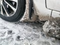 The wheel arch of the car is clogged with ice and snow