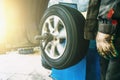 Wheel balancing or repair and change car tire at auto service garage or workshop by mechanic Royalty Free Stock Photo