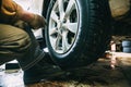 Wheel balancing or repair and change car tire at auto service garage or workshop by mechanic Royalty Free Stock Photo