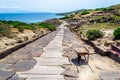 Wheel barrow and brooms on a downhill path in Tharros Royalty Free Stock Photo